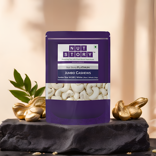 Purple package of Nut Story Jumbo Cashews on a dark surface with decorative elements.